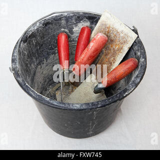 Black plastic bucket filled with masonry tools Stock Photo
