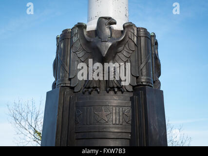 American Bald Eagle emblem cast in bronze at the base of a flagstaff pedestal with stars and stripes symbols in Fort Tryon Park Stock Photo