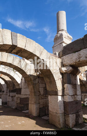 Ancient white broken columns and arches on blue sky background, fragment of ruined roman temple in Smyrna. Izmir, Turkey Stock Photo