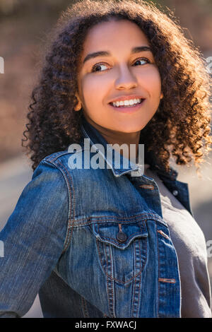 Outdoor portrait beautiful happy mixed race African American girl teenager female young woman smiling laughing and perfect teeth Stock Photo