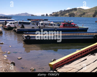 Ferries crossing Lake Titicaca with lorries and cars loaded on small boats at Copacabana, Bolivia Stock Photo