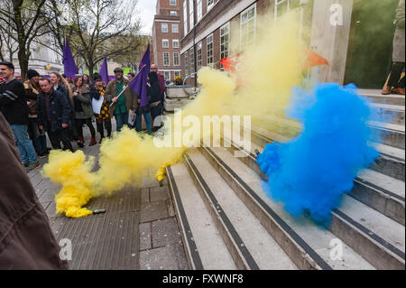 London, UK. 18th April, 2016. As the rally demanding the SOAS cleaners be brought in-house and accored the same dignity and respect as other SOAS workerscame to an end blue and yellow smoke flares were set off on the bottom of the steps leading to the entrance of SOAS. Peter Marshall/Alamy Live News Stock Photo