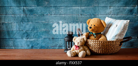Cute teddy bear in a basket on a wooden table Stock Photo