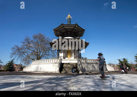 A skateboarder outside the London Peace Pagoda in Battersea Park, alongside River Thames, London, England, UK Stock Photo