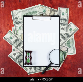 Blank paper sheet in clipboard placed on center of money dollar and wood background, coffee cup, business concept and informatio Stock Photo