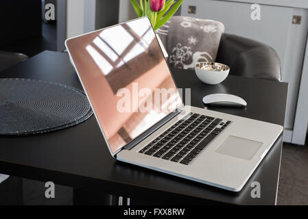 laptop with window reflection standing on table Stock Photo