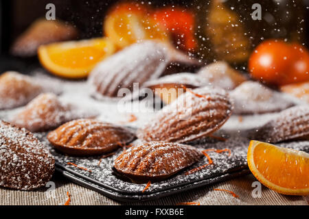 Homemade orange honey madeleines cookies and sugar powder motion Stock Photo