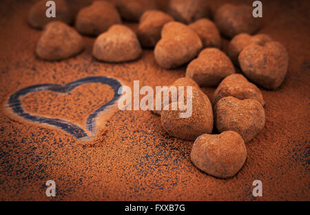 Heart shaped chocolate truffles on cocoa powdered table, Valentine concept Stock Photo