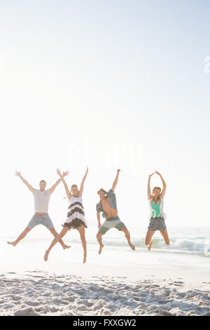 Happy friends jumping on the beach Stock Photo