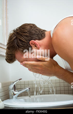 Man washing his face in the bathroom Stock Photo