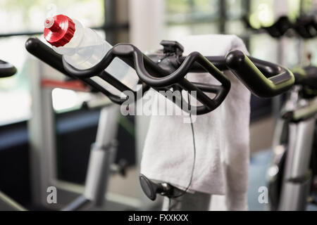 Bottle of water and napkin on exercise bike Stock Photo