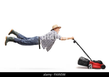 Mature gardener being pulled by a powerful lawn-mower isolated on white background Stock Photo