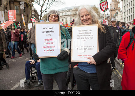 A couple each with their own home made sign showing their support for the anti-austerity march in London especially the doctors. Stock Photo