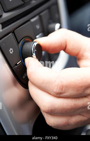 Close Up Of Hand Adjusting Car Air Conditioning Control On Dashboard Stock Photo