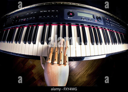 Wooden hand on digital piano key board. Stock Photo