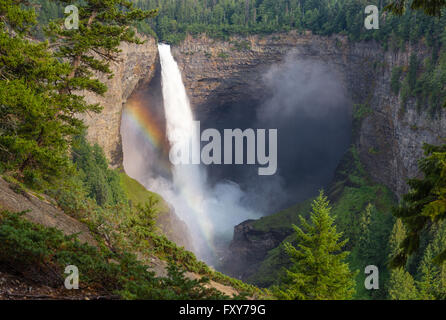 Rainbow appears in mist at sunlit Helmcken Falls, Wells Gray Provincial Park, BC Stock Photo