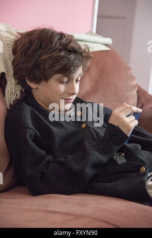 Boy relaxing and using his smartphone. Stock Photo