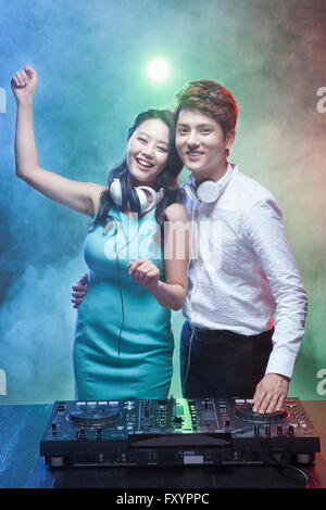 Young smiling woman dancing with smiling DJ at nightclub Stock Photo