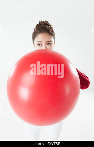 Portrait of young woman blowing a big balloon Stock Photo