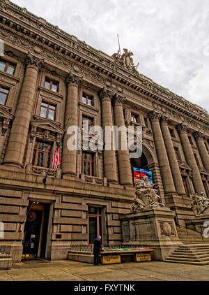 NEW YORK, USA - APRIL 24, 2015: Alexander Hamilton US Custom House, Lower Manhattan, New York, USA. Now it is the National Museum of American Indians. Tourist nearby Stock Photo