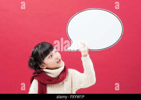Portrait of gril wearing a muffler holding a speech balloon looking up Stock Photo