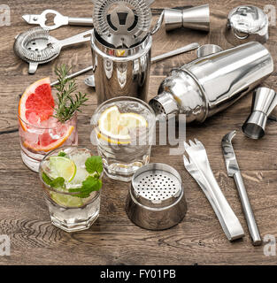 Drinks with ice and tonic water. Cocktail making bar accessories, shaker, glasses, mint leaves Stock Photo