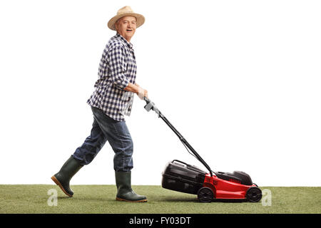 Profile shot of a mature man mowing a lawn with a lawnmower isolated on white background Stock Photo