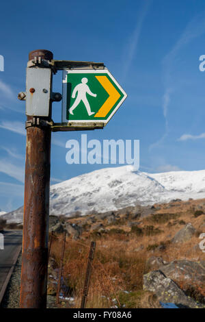 Footpath sign in Ogwen Valley with Pen yr Ole Wen mountain in snow in background Snowdonia National Park Gwynedd North Wales UK Stock Photo