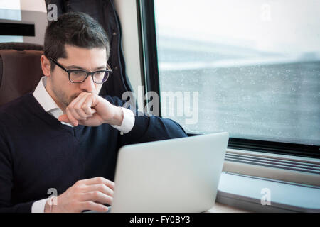 man working with computer on a train Stock Photo