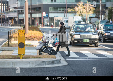 Woman with baby carriage in Akasaka district in Minato special ward, Tokyo city, Japan Stock Photo