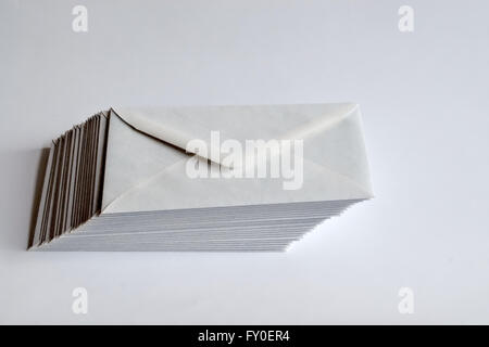 Stack of plain white envelopes shifted to right on white background. Stock Photo