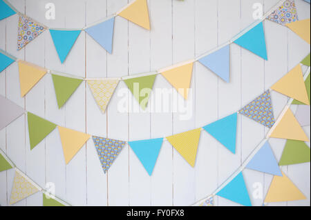 Birthday decoration flags on a plain white wall shot with tilt and shift Stock Photo