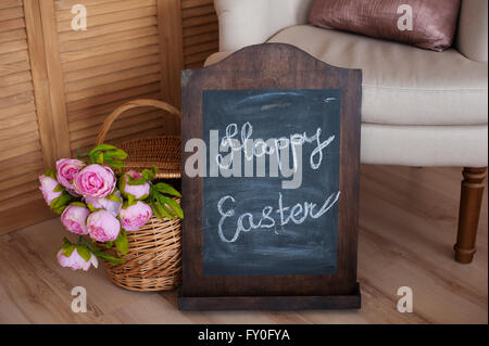 bouquet of flowers in a basket and words happy easter  on blackboard Stock Photo