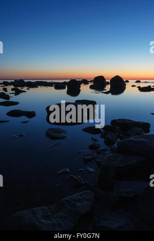 Calm and rocky seashore in the early morning, long exposure shot Stock Photo