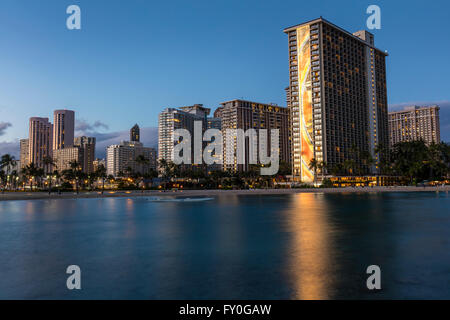 A view of the Hilton Hawaiian Village Waikiki Beach Resort and surrounding hotels at dusk. Stock Photo