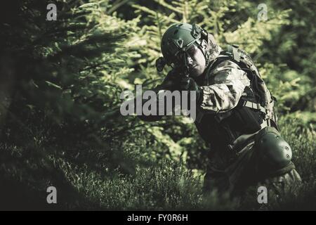 A Camouflaged Sniper Sitting In The Woods Aiming Through His Scope Stock  Photo, Picture and Royalty Free Image. Image 42659284.