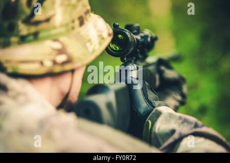 Wildlife Hunting. Camouflaged Hunter with Powerful Rifle with Scope Spotting Animals. Stock Photo