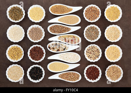 Grain and cereal food selection in porcelain bowls over lokta paper background. Stock Photo