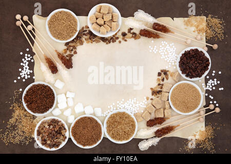 Brown and white sugar with crystal lollipops over parchment and  brown paper background. Stock Photo