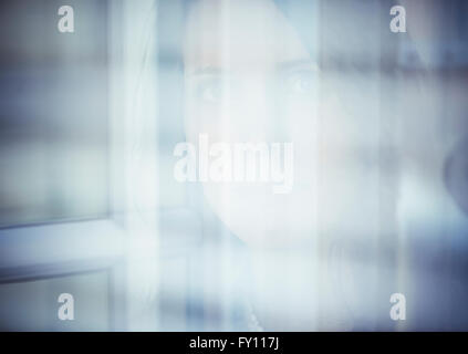 Portrait of anxiuos woman by a window. Concept of sadness, fear and uncertainty. Stock Photo