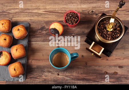 Retro coffee grinder, coffee mill coffee cup, chocolate cupcake, muffins, coffee beans. Still, restaurant, coffee shop. Wood bac Stock Photo