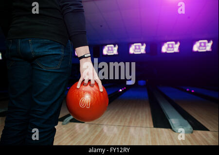 Hand of man player with bracelet holding bowling ball Stock Photo