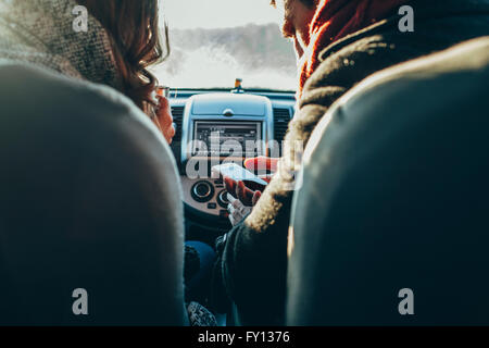 Cropped image of couple using smart phone in car Stock Photo