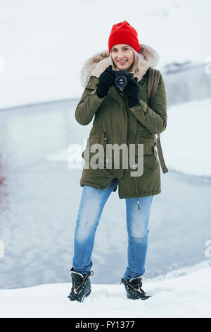 Beautiful young woman photographing through camera during winter Stock Photo