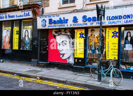 Front window of a local clothes shop with a cool graffiti showing a woman with tongue sticking out. Stock Photo