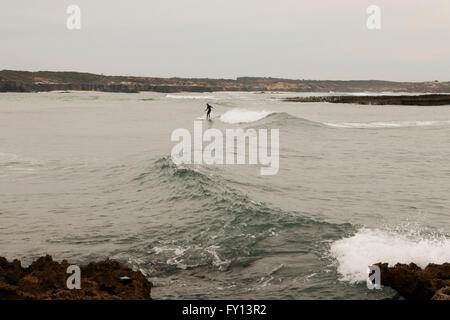 person-surfing-at-beach-vila-nova-de-milfontes-portugal-stock-photo