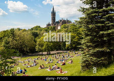 View of Kelvingrove Park full of people enjoying the Scottish summer with main building of Glasgow University on the top of hill Stock Photo