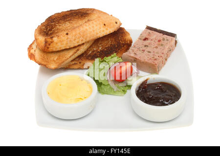 Farmhouse pate with toast, salad, butter and red onion marmalade on a plate isolated against white Stock Photo