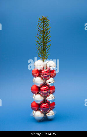 Christmas tree made of twig and ornaments against blue background Stock Photo