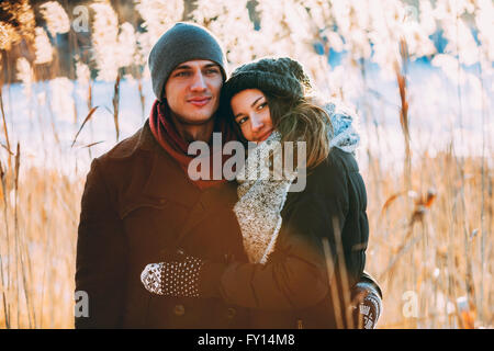 Young couple embracing while standing on field Stock Photo